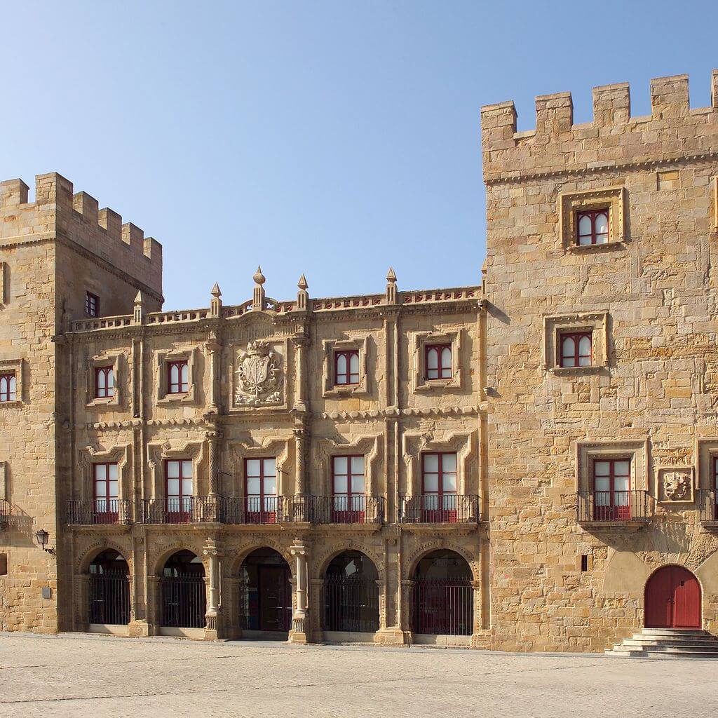Vista de la fachada del Palacio de Revillagigedo, donde se ven los arcos de entrada flanqueados por las dos torres