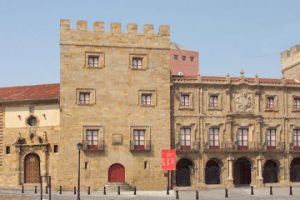 Miniatura de la vista parcial del Palacio de Revillagigedo, podemos ver la entrada a la Colegiata, adyacente al Palacio, una de las torres y la fachada principal