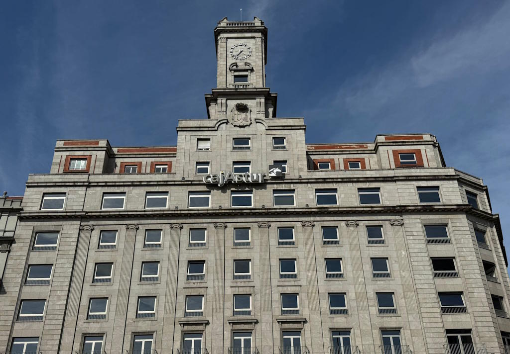 Vista de la fachada de la sede de Cajastur, situado en una plaza en un entorno peatonalizado y con un gran reloj coronando el edifico