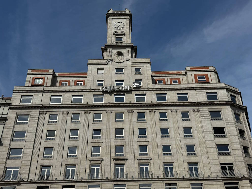 Vista de la fachada de la sede de Cajastur, situado en una plaza en un entorno peatonalizado y con un gran reloj coronando el edifico
